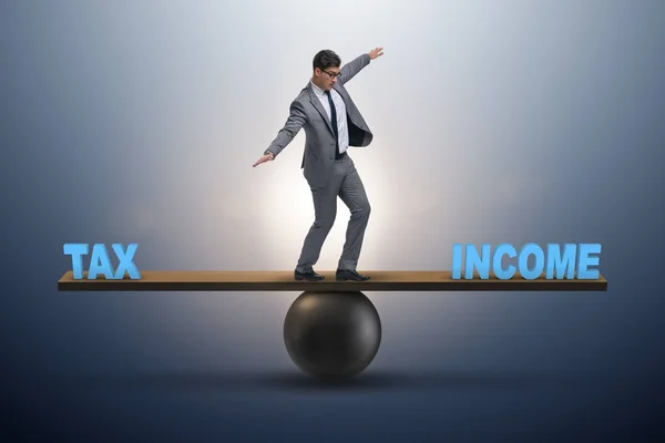 Forretningsmann balanserer mellom inntekt og skatt i forretningskonseptet – stockfoto