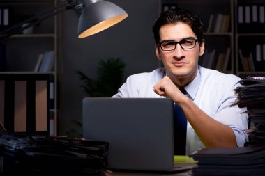 Genç işadamı geç saatlere kadar ofiste çalışıyor.