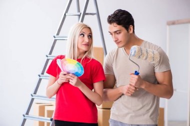 Ev tadilatı sırasında genç bir aile boya işi yapıyor.