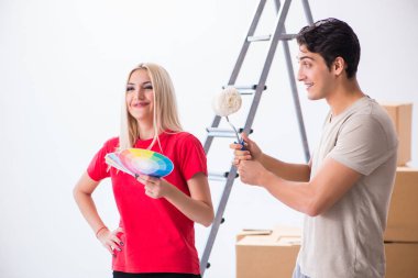 Ev tadilatı sırasında genç bir aile boya işi yapıyor.