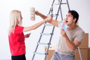 Ev tadilatı sırasında genç bir aile boya işi yapıyor.