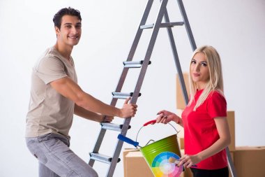 Ev tadilatı sırasında genç bir aile boya işi yapıyor.