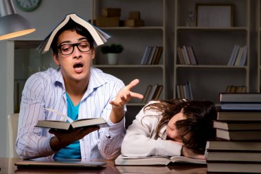 İki öğrenci geç saatlere kadar çalışıp sınavlara hazırlanıyor.