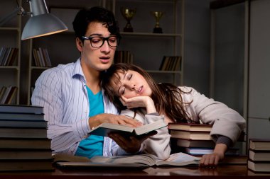 İki öğrenci geç saatlere kadar çalışıp sınavlara hazırlanıyor.