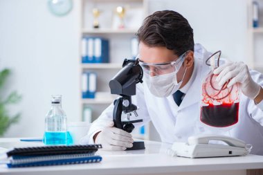 Hastane kliniğinde kan örnekleriyle çalışan bir doktor.