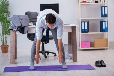 İş adamı tatilde ofiste spor yapıyor.