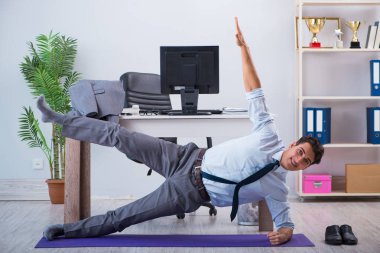 İş adamı tatilde ofiste spor yapıyor.