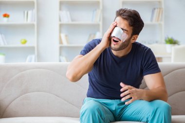 Genç adam estetik cerrahi burnundan sonra evde iyileşiyor.