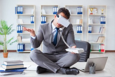 Sanal gerçeklikteki iş adamı VR gözlükleri masanın üstünde meditasyon yapıyor.