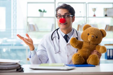Hastane kliniğinde oyuncak taşıyan komik bir çocuk doktoru.
