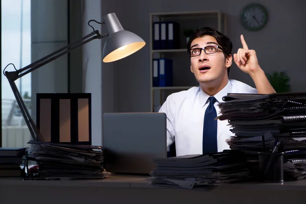 Joven hombre de negocios trabajando horas extras hasta tarde en el cargo — Foto de Stock