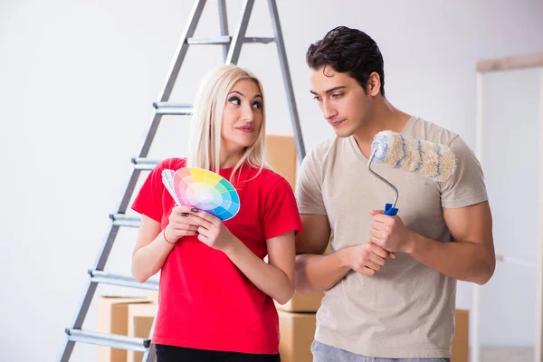 Família jovem fazendo trabalho de pintura durante a renovação da casa — Fotografia de Stock