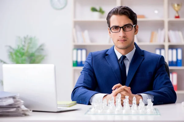 Joven hombre de negocios jugando ajedrez de vidrio en la oficina — Foto de Stock
