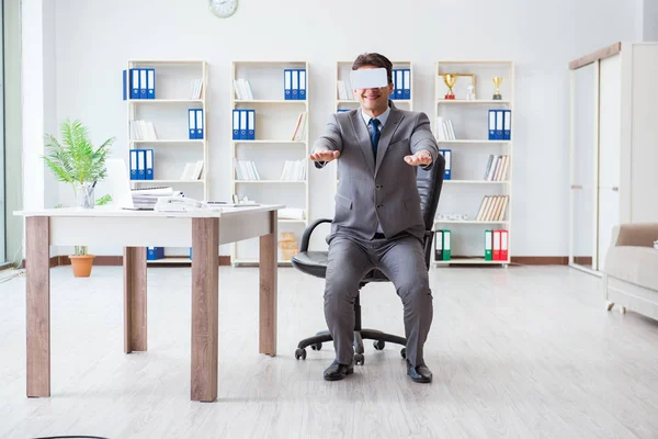 Ofiste egzersiz yapan işadamı VR gözlüğü takıyor.