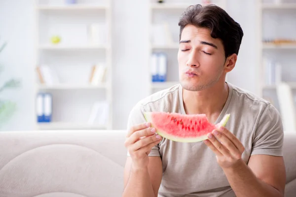 Mann isst Wassermelone zu Hause — Stockfoto