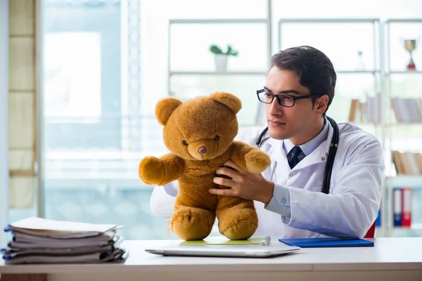 Ofiste oyuncaklı bir çocuk doktoru oturuyor. — Stok fotoğraf