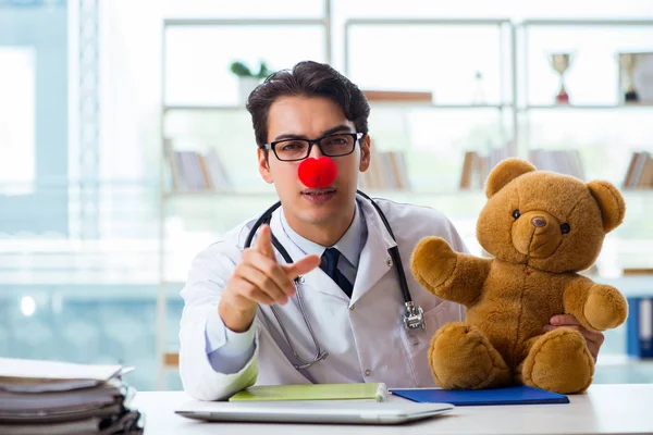 Hastane kliniğinde oyuncak taşıyan komik bir çocuk doktoru. — Stok fotoğraf