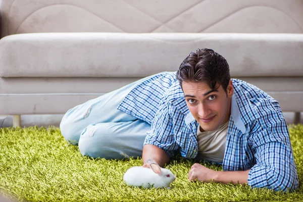 Młody mężczyzna zabawia się w domu ze zwierzątkiem domowym — Zdjęcie stockowe