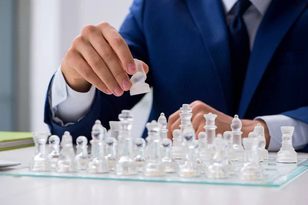 Young businessman playing glass chess in office — Stock Photo, Image