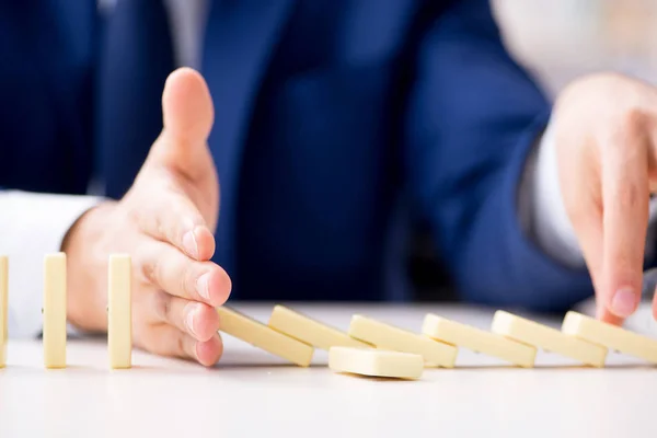 Ung affärsman leker med domino i ämbetet — Stockfoto