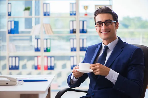 Бизнесмен пьет кофе в офисе во время перерыва — стоковое фото