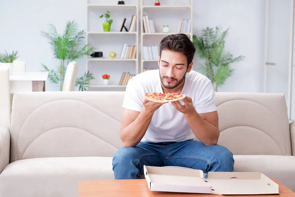 Homme mangeant de la pizza ayant un plat à emporter à la maison détente au repos — Photo