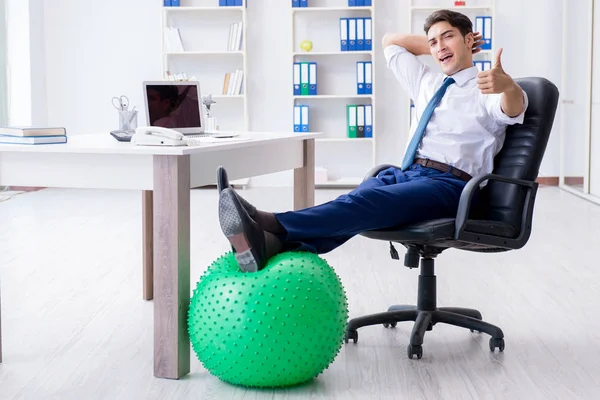 Young businessman doing sports stretching at workplace — Stock Photo, Image