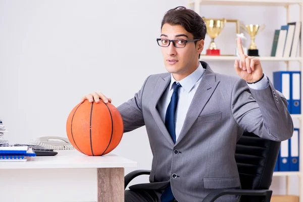 Jovem empresário jogando basquete no escritório durante o intervalo — Fotografia de Stock