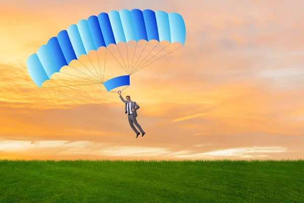 Young businessman falling on parachute in business concept — Stock Photo, Image