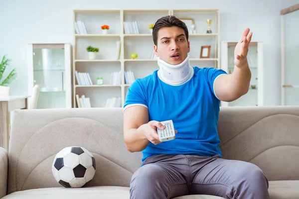 Hombre con lesión en el cuello viendo fútbol fútbol en casa — Foto de Stock