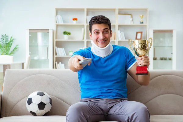 Uomo con infortunio al collo guardando calcio a casa — Foto Stock