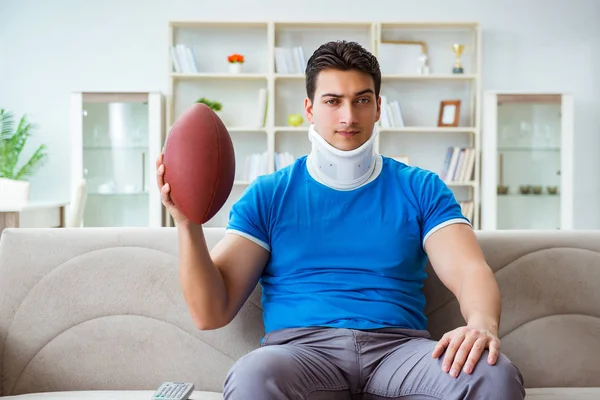 Hombre con lesión en el cuello viendo fútbol americano en casa —  Fotos de Stock