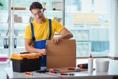 Mobilya marangozu atölyede çalışıyor.