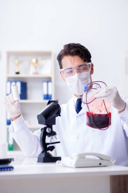 Hastane kliniğinde kan örnekleriyle çalışan bir doktor.
