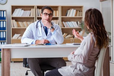 Hamile kadın muayene için doktoru ziyaret ediyor.