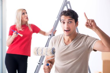 Ev tadilatı sırasında genç bir aile boya işi yapıyor.