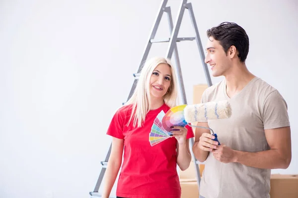 Família jovem fazendo trabalho de pintura durante a renovação da casa — Fotografia de Stock