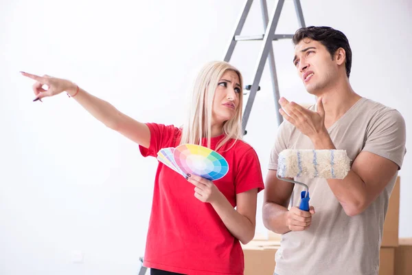 Família jovem fazendo trabalho de pintura durante a renovação da casa — Fotografia de Stock