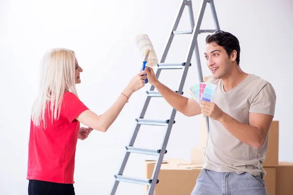 Família jovem fazendo trabalho de pintura durante a renovação da casa — Fotografia de Stock