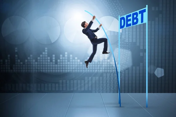 Businessman pole vaulting over debt in business concept — Stock Photo, Image