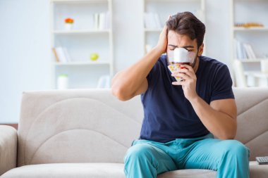 Genç adam estetik cerrahi burnundan sonra evde iyileşiyor.