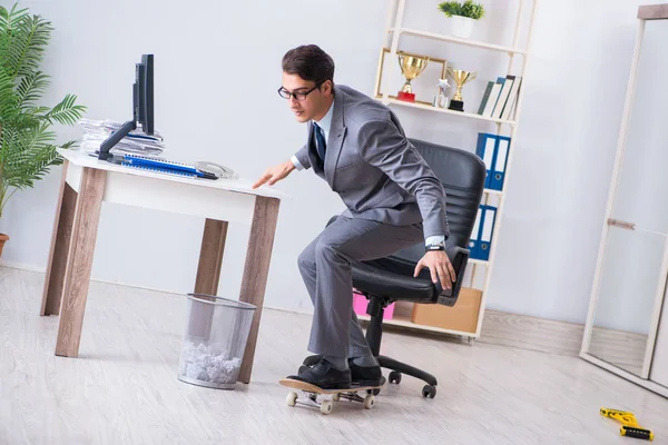 Młody biznesmen jeżdżący na łyżwach w biurze podczas przerwy — Zdjęcie stockowe