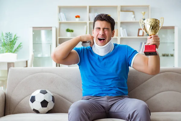 Hombre con lesión en el cuello viendo fútbol fútbol en casa — Foto de Stock