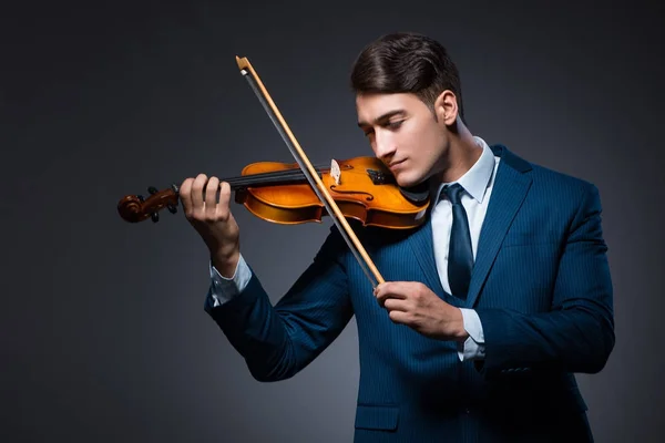 Jovem tocando violino no quarto escuro — Fotografia de Stock