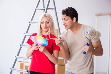 Ev tadilatı sırasında genç bir aile boya işi yapıyor.