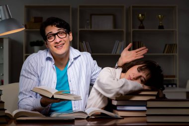 İki öğrenci geç saatlere kadar çalışıp sınavlara hazırlanıyor.