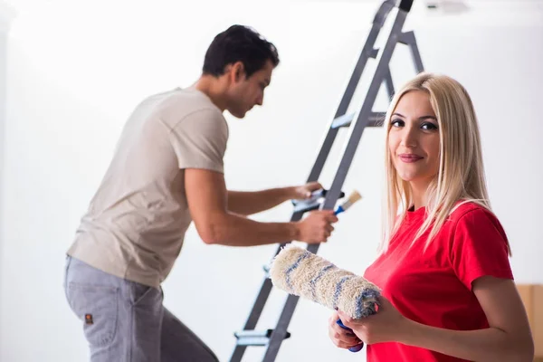 Família jovem fazendo trabalho de pintura durante a renovação da casa — Fotografia de Stock