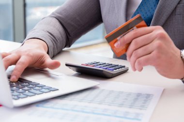 Erkek işadamı kredi kartıyla online alışveriş yapıyor.