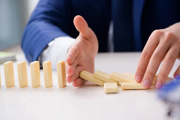 Młody biznesmen gra z domino w biurze — Zdjęcie stockowe