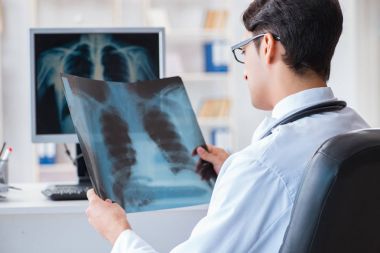 Doktor radyoloji uzmanı röntgen görüntülerine bakıyor.